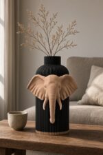 Vaso Elefante Black Creme, corpo nero con decorazione e bordo alla base color crema, ambientato con rami secchi.