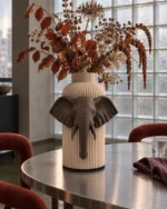 Vaso Elefante marrone e crema della Marrone e Crema Collection, ambientato con rami decorativi e foglie secche.