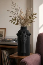 Vaso Giraffa Elegante nero della Black Collection, ambientato con rami decorativi e foglie secche.