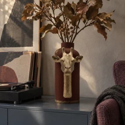 Vaso Giraffa Elegante marrone con decorazione color oro, ambientato con una composizione di rami secchi.