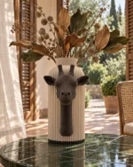 Vaso Giraffa marrone e crema della Marrone e Crema Collection, ambientato con rami decorativi e foglie secche.