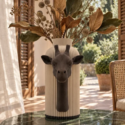 Vaso Giraffa marrone e crema della Marrone e Crema Collection, ambientato con rami decorativi e foglie secche.