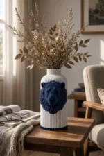 Vaso Leone con corpo chiaro effetto marmo e decorazione blu notte, della Marble and Blue Collection, ambientato con rami decorativi e foglie secche.