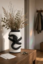 Vaso Serpente bianco e nero della Black and White Collection, ambientato con rami decorativi e foglie secche.