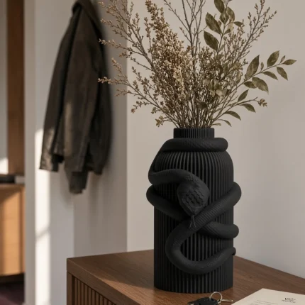 Vaso Serpente Avvolgente nero della Black Collection, ambientato con rami decorativi e foglie secche.