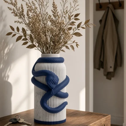 Vaso Serpente con corpo chiaro effetto marmo e decorazione blu notte, della Marble and Blue Collection, ambientato con rami decorativi e foglie secche.